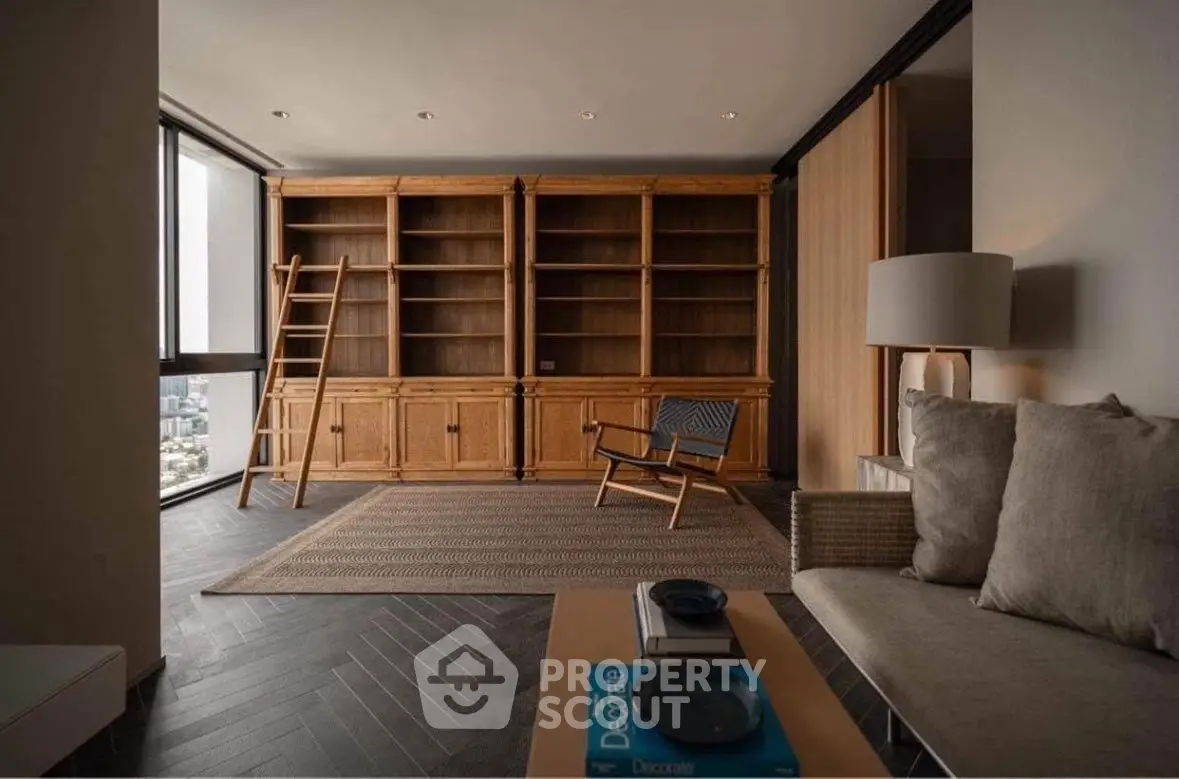 Spacious living room with wooden bookshelves and city view, perfect for relaxation and reading.