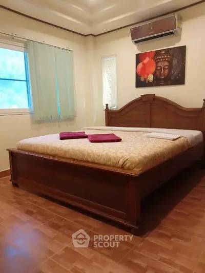 Cozy bedroom with wooden bed and air conditioning, perfect for relaxation.