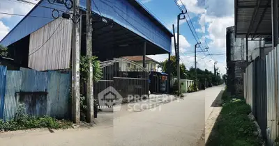 Industrial warehouse with gated entrance on a quiet street, ideal for business operations.
