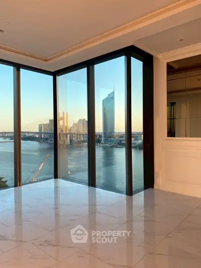 Luxurious high-rise apartment with stunning river and city views through floor-to-ceiling windows.