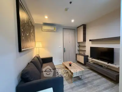 Modern living room with stylish furniture and wall art, featuring a cozy sofa and flat-screen TV.