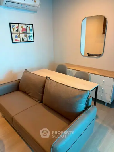 Modern living room with stylish sofa, wall art, and sleek furniture in a cozy apartment.