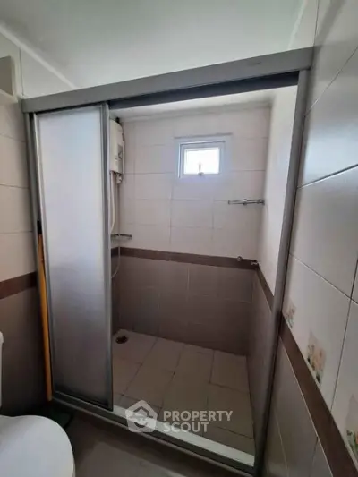 Compact bathroom with sliding shower door and small window