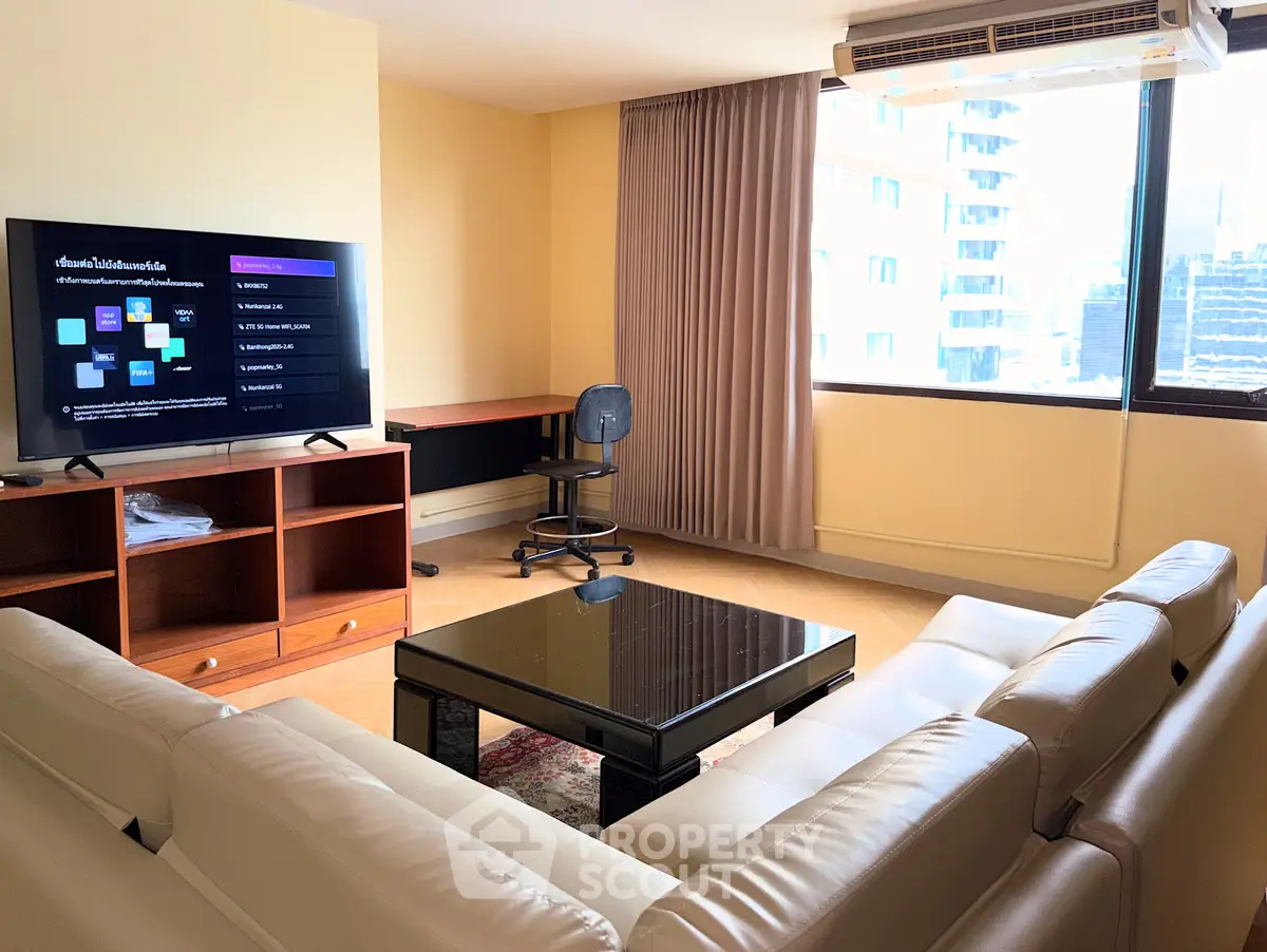 Spacious living room with modern furniture and city view, perfect for relaxation and entertainment.