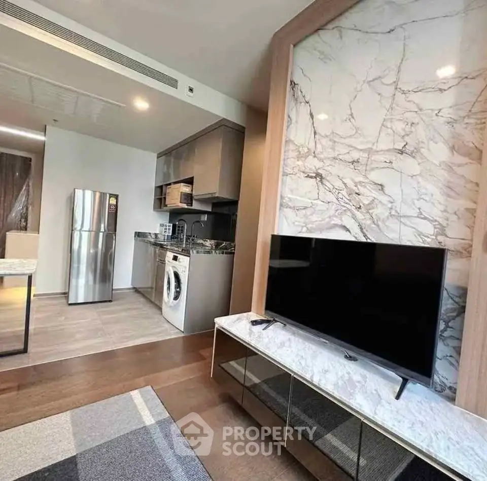Modern open-layout kitchen and living area with marble accents and sleek appliances.