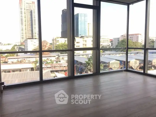 Spacious corner unit with floor-to-ceiling windows offering a panoramic city view.