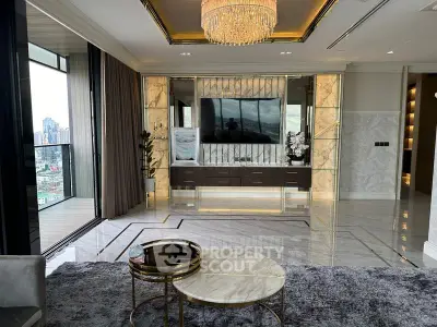 Luxurious living room with modern decor and city view balcony, featuring elegant chandelier and marble flooring.