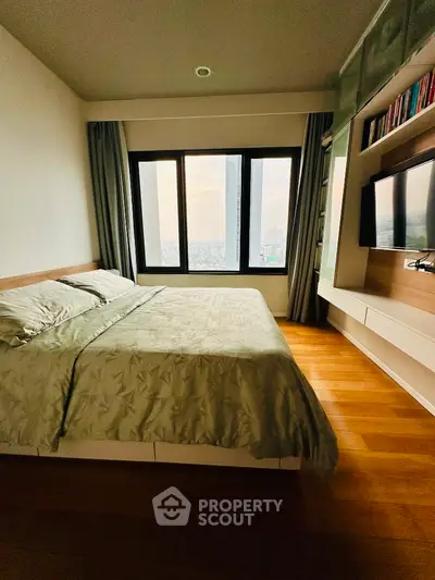 Modern bedroom with large window and built-in TV unit, offering stunning city views.