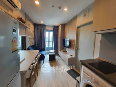 Modern open-plan living room with kitchen, featuring sleek furniture and appliances.
