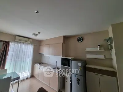 Modern kitchen with sleek cabinetry and dining area in a bright apartment