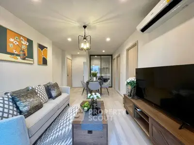 Stylish modern living room with elegant decor and open layout, featuring a cozy sofa and large TV.