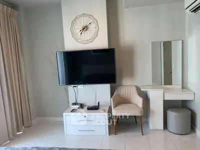 Modern living room with wall-mounted TV and stylish furniture
