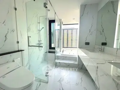 Luxurious marble bathroom with glass shower and modern fixtures