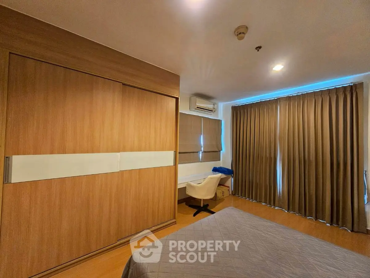 Spacious bedroom with modern design, featuring large windows and ample storage space.