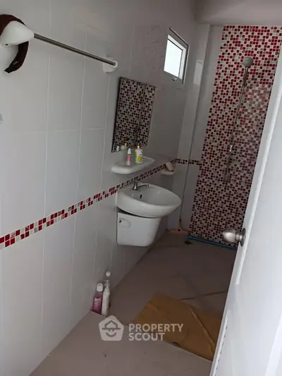 Modern bathroom with red mosaic tiles and sleek fixtures