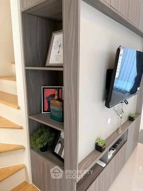 Modern living room with stylish shelving and mounted TV, perfect for contemporary home decor.