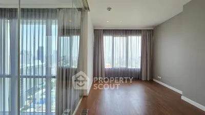 Spacious empty room with large windows and city view, perfect for customization.