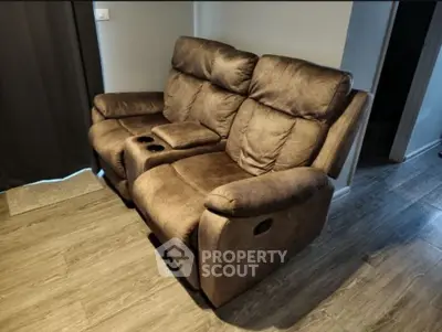Cozy living room with plush brown recliner sofa and wooden flooring