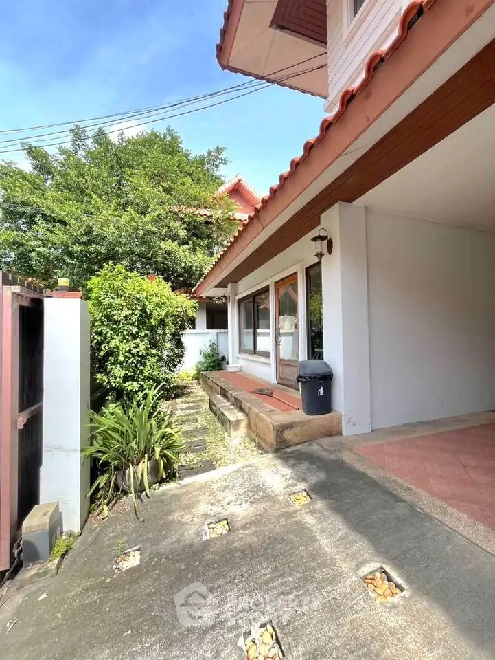 Charming suburban home with lush greenery and inviting entrance, perfect for family living.