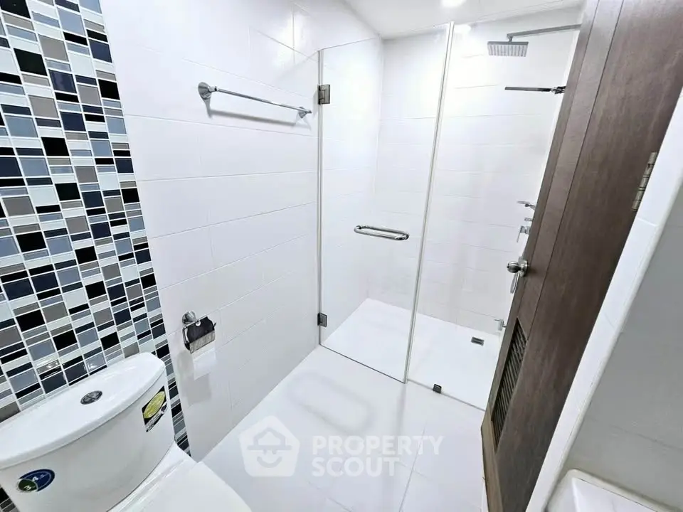 Modern bathroom with glass shower enclosure and stylish tile accents