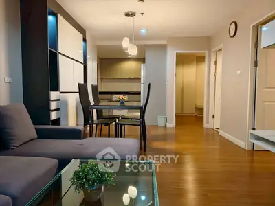 Modern living room with sleek furniture and open kitchen layout, perfect for urban living.
