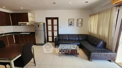 Spacious living room with modern kitchen and stylish furniture in open layout apartment.