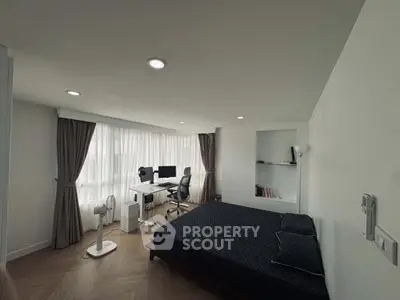 Spacious bedroom with study area and large windows in modern apartment