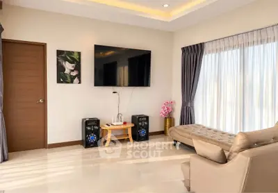 Modern living room with stylish decor, large TV, and elegant furniture, perfect for relaxation and entertainment.