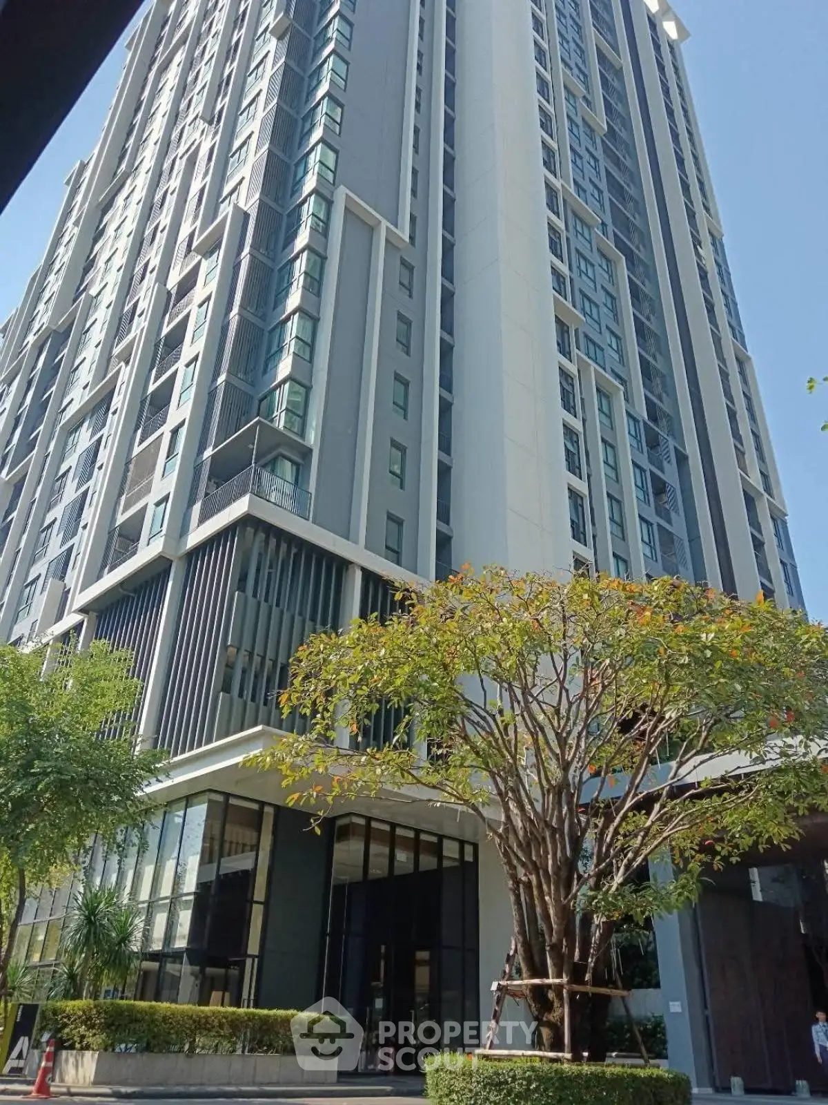 Modern high-rise building with lush greenery and sleek architectural design