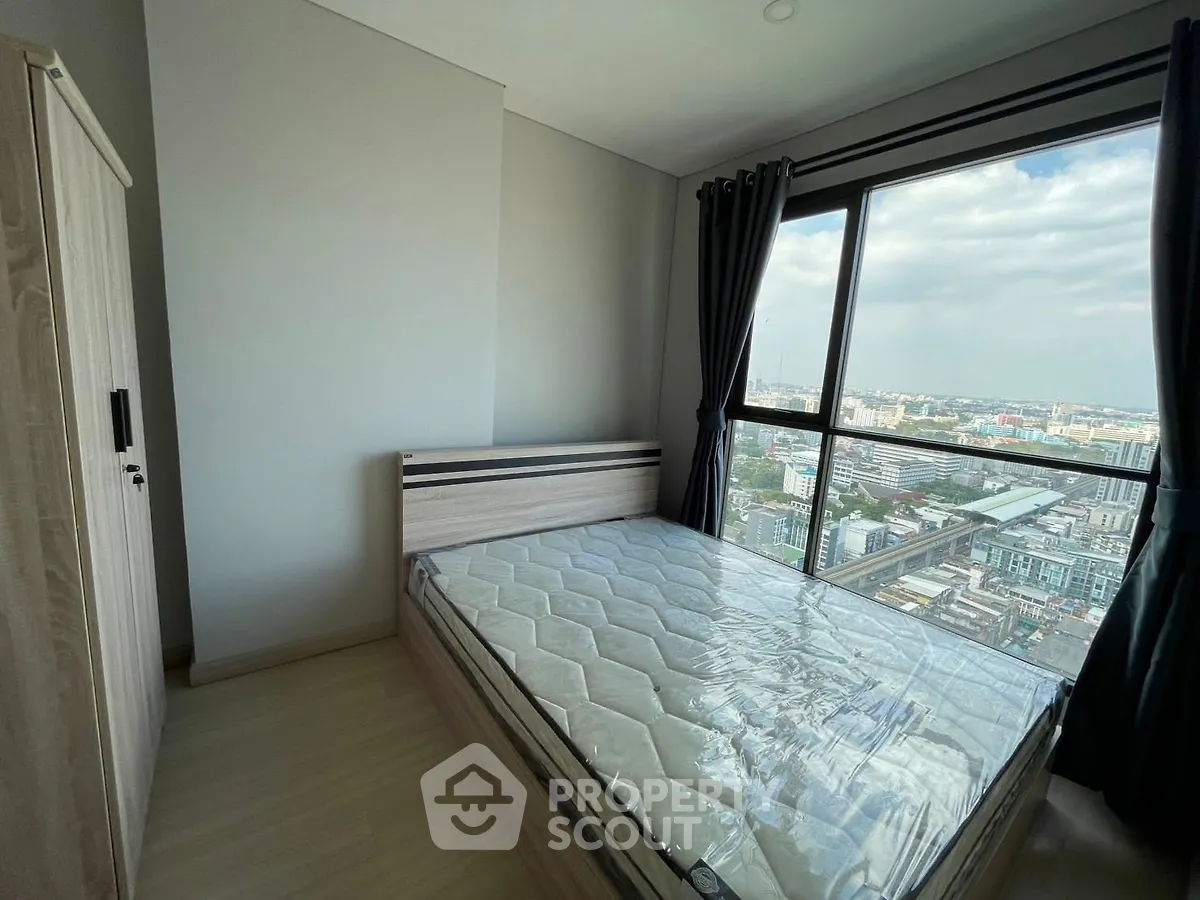Modern bedroom with large window offering stunning city view