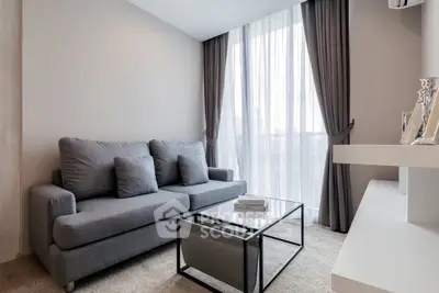Modern living room with sleek gray sofa and floor-to-ceiling windows