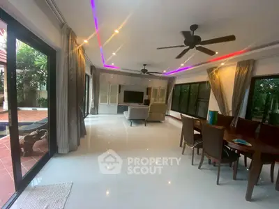 Spacious living room with modern lighting and pool view