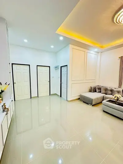 Spacious modern living room with elegant ceiling lights and cozy sectional sofa.