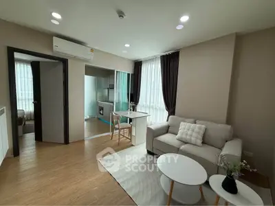 Modern living room with cozy sofa, stylish decor, and natural light from large windows.