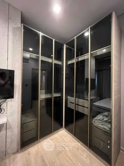 Modern bedroom with sleek glass wardrobes and cozy ambiance