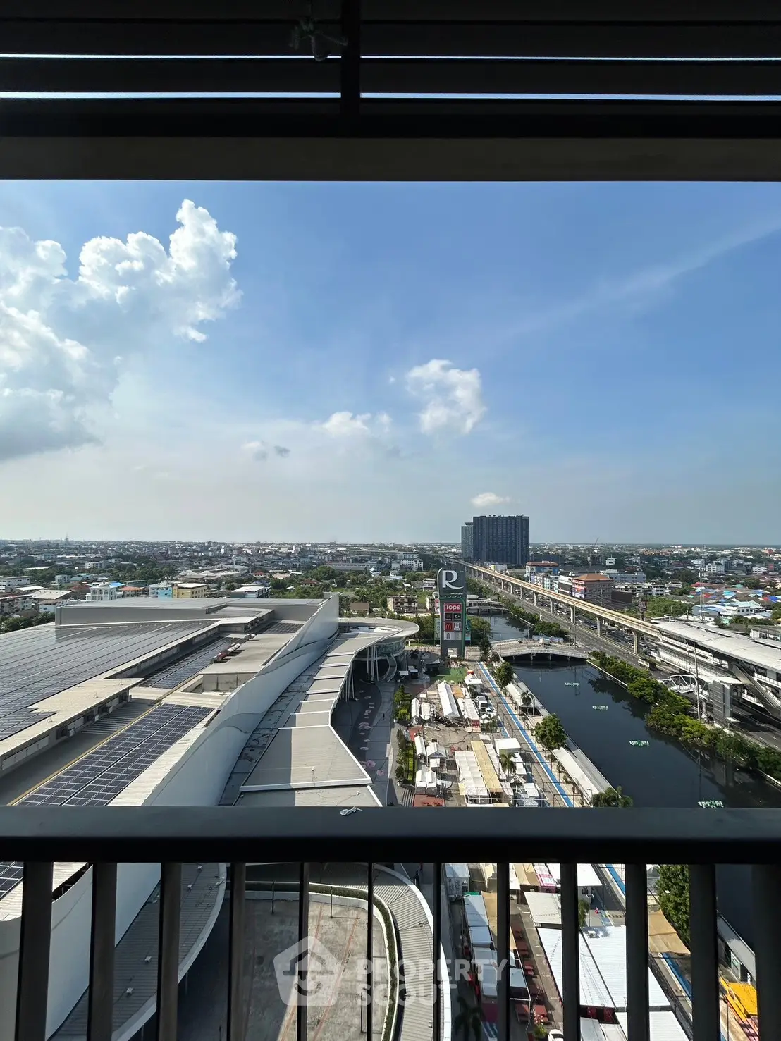 Stunning cityscape view from a high-rise balcony overlooking urban skyline and river.