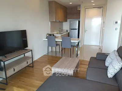 Modern living room with open kitchen, stylish furniture, and wooden flooring