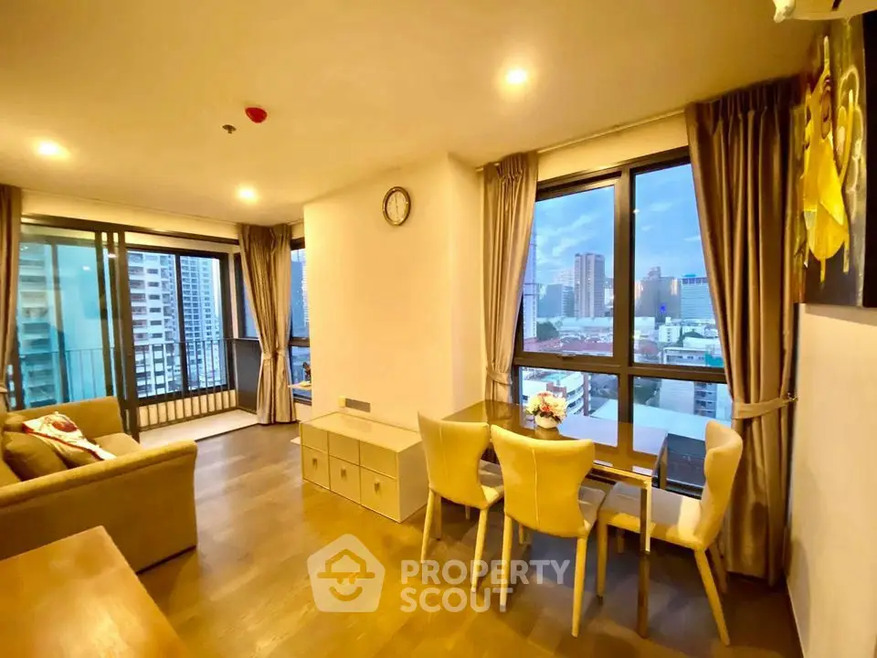 Spacious living room with city view and elegant dining area in modern apartment.