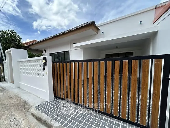 Modern single-story house with stylish wooden gate and clean exterior design.