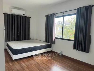 Spacious bedroom with large window and modern decor