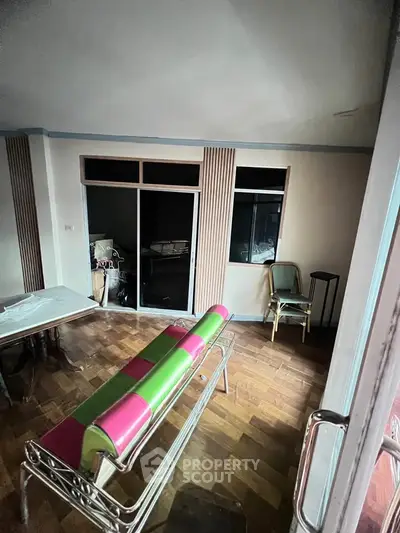 Spacious living room with wooden flooring and modern furniture in a stylish apartment.