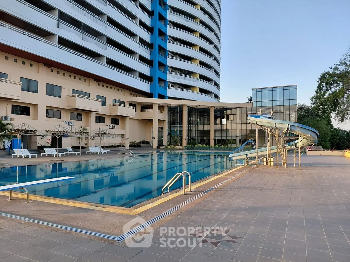 Luxurious apartment complex with a stunning outdoor pool and water slide, perfect for relaxation and leisure.