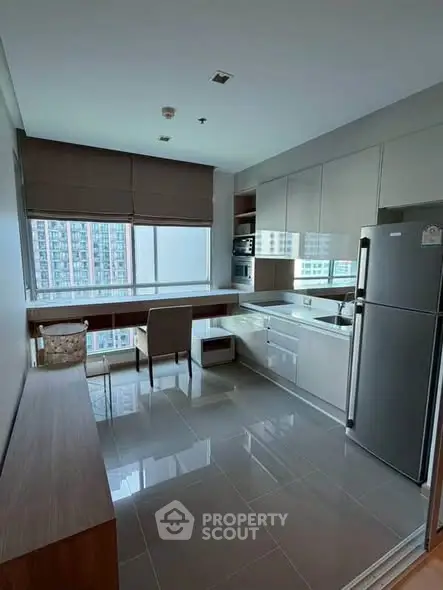 Modern kitchen with sleek cabinetry and large window view in urban apartment