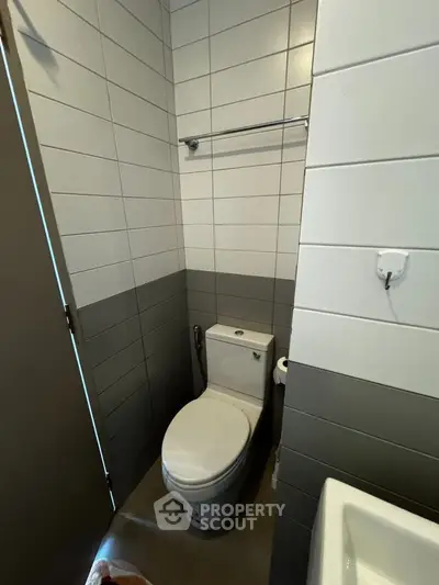 Modern bathroom with sleek tile design and contemporary toilet setup.