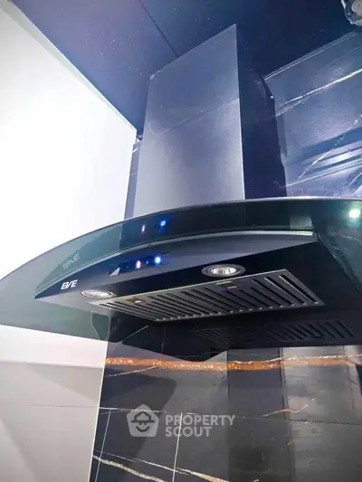 Modern kitchen with sleek black range hood and stylish tile backsplash.