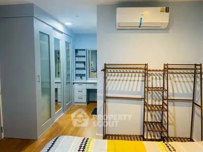 Modern bedroom with built-in wardrobe and air conditioning unit