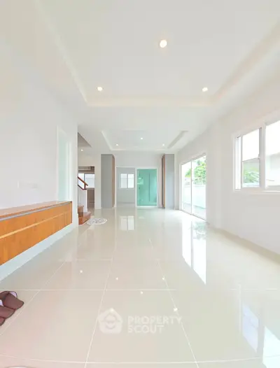 Spacious modern living room with glossy tile flooring and large windows for natural light.