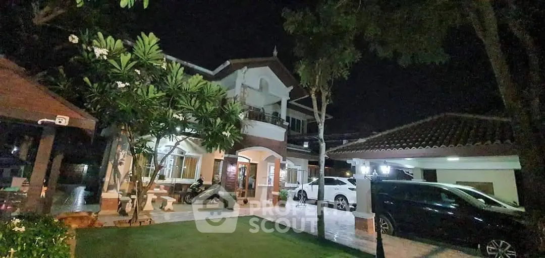 Charming two-story house with lush garden and carport, perfect for serene living.