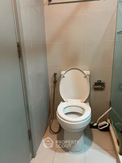Compact bathroom with modern toilet and tiled walls, ideal for urban living spaces.