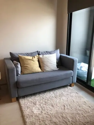 Cozy living room with stylish gray sofa and large window for natural light.
